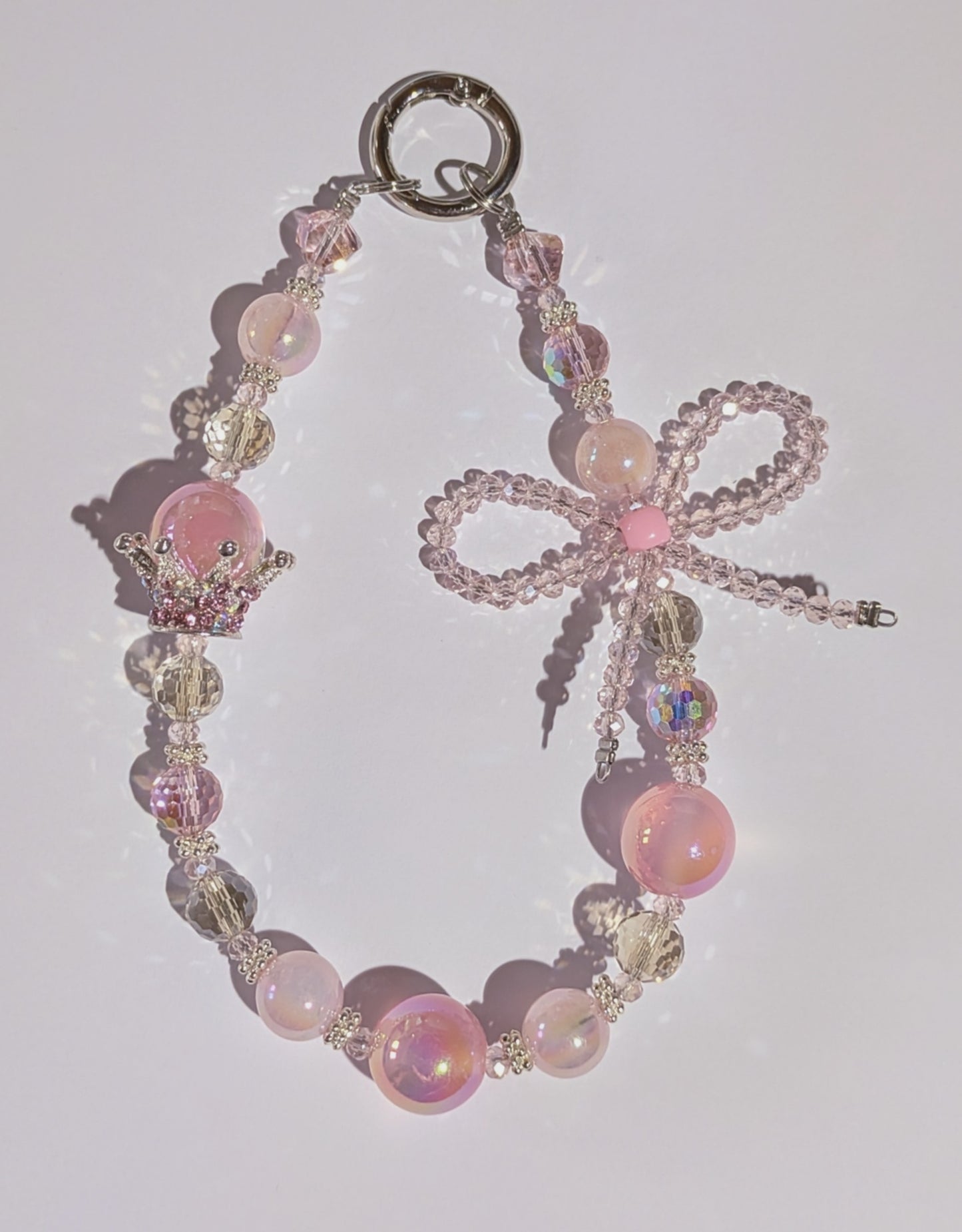 Hochwertige Handykette aus Glas- und Metallperlen in Rosa mit Krone und Perlenschleife
