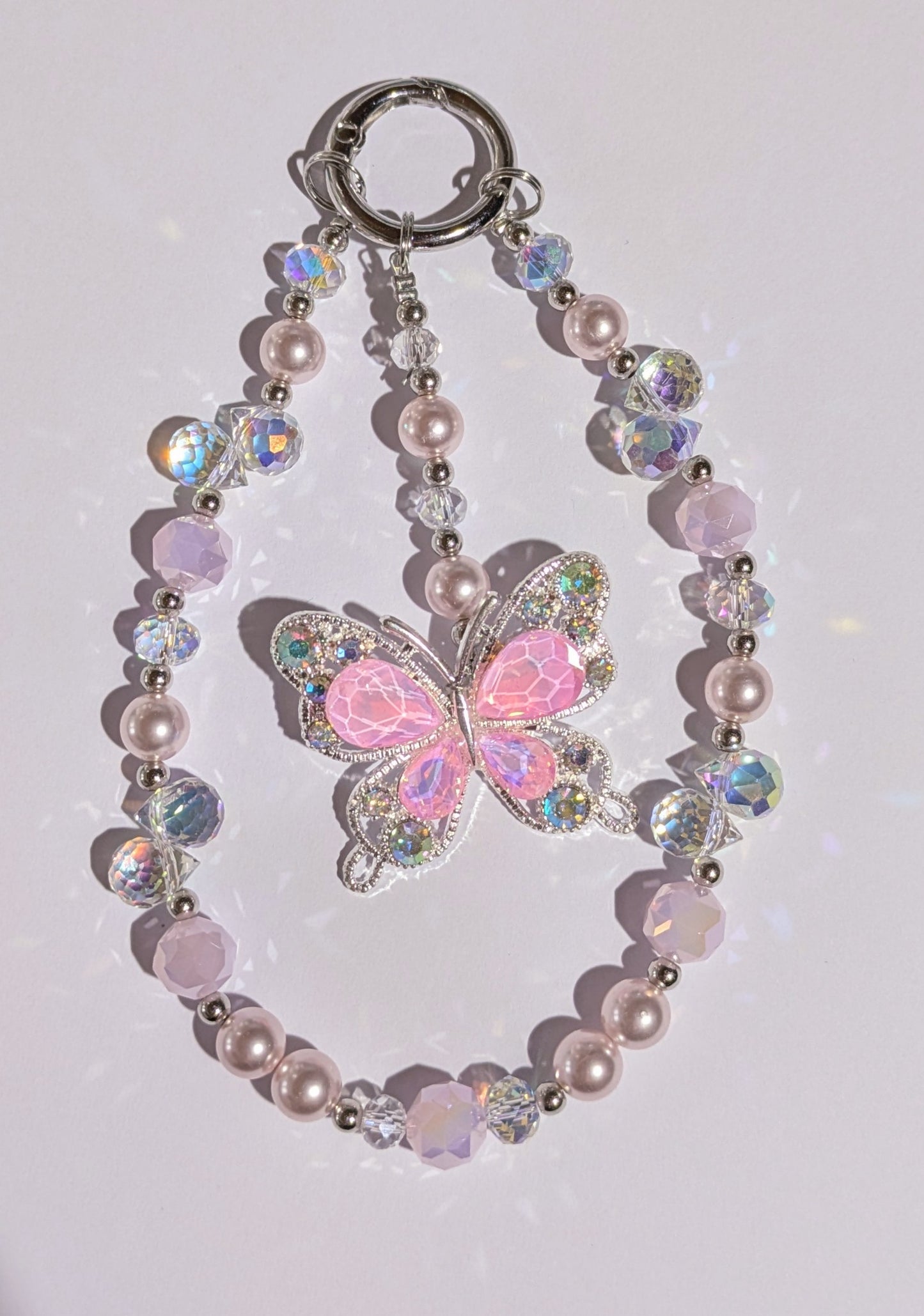 Hochwertige Handykette aus Glas- und Metallperlen in rosa mit großer Metallschmetterlingsperle